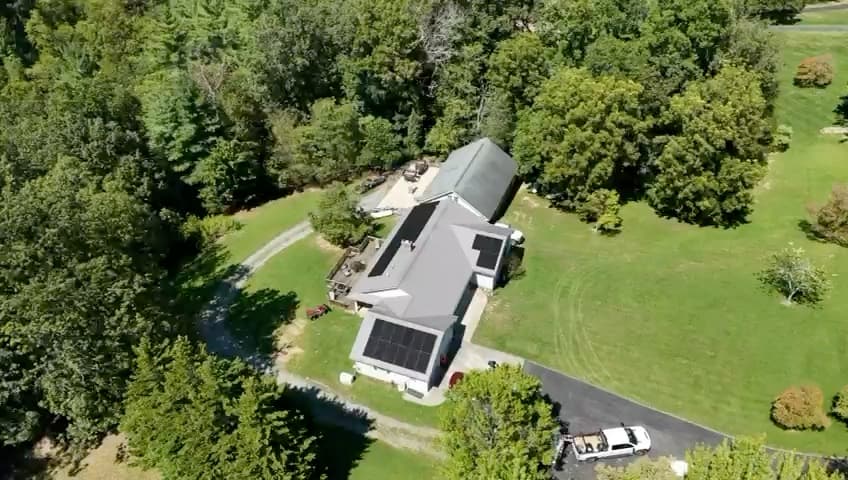 Aerial view of a residential solar array surrounded by mature trees